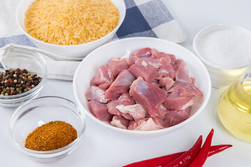 Prepared ingredients for cooking pilaf in modern multi cooker in kitchen on a table. Cooking pilau...
