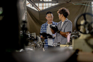 Men are inspecting steel parts for machine installation. team of teacher and student are learning to use heavy machines in steel factory. workers cooperate while doing quality control of manufactured.