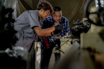 Men are inspecting steel parts for machine installation. team of teacher and student are learning to use heavy machines in steel factory. workers cooperate while doing quality control of manufactured.
