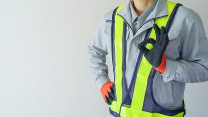 OKポーズをする作業服の男性｜建設業・警備員・ガードマン　イメージ