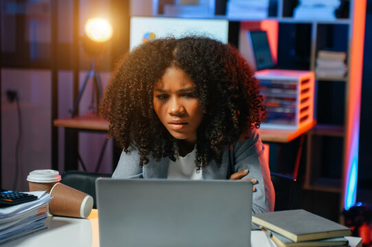 Business woman drinking coffee to get some energy for working overtime sitting at desk using computer and doing overtime