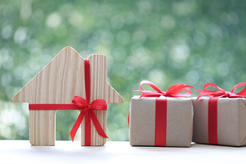 Real estate and Gift new home concept,Model house and gift box with red ribbon for Christmas and New Year's Day or Greeting season