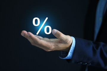 Businessman hand holding with percentage symbol on dark background, Interest rate and business...
