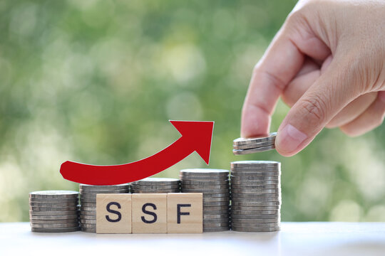 Red arrow on coins money and ssf word on natural green background, SSF (Super Saving Funds) concept