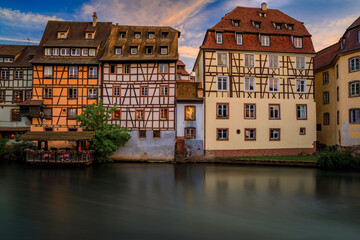 Obraz premium Ornate traditional half timbered houses with blooming flowers along the canals in the Petite France district of Strasbourg, Alsace, France at sunset