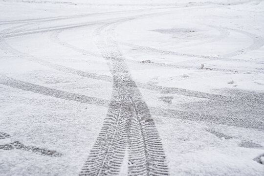 Tracks of winter tires and boots on a snowy road