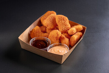 Delicious fresh crispy chicken nuggets on a dark background. Unhealthy food, fast food