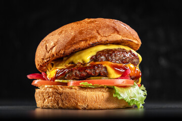 Delicious double cheeseburger close up on a black background. Delicious cheeseburger. sandwich fast...