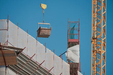 Cantiere edile: Una gru solleva un  carico di  detriti