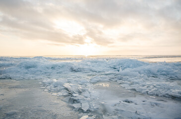 Large pieces of ice near the river bank at sunset