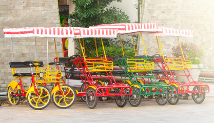 Fototapeta na wymiar Bicycle with four wheels on the square on soft sunlight