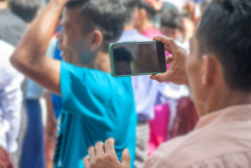 Man holding smart phone mobile shooting burmese people dress in national costumes, Come out to participate and dance in the Kathin festival