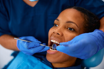 Black woman during teeth examination at dentist's office.