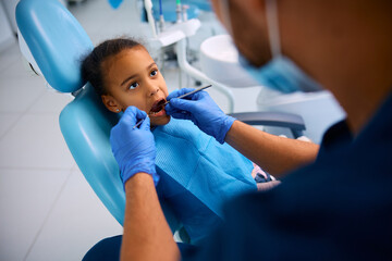 Small black girl during appointment at dentist's office.