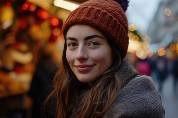 A woman wearing a red knitted hat with a warm smile. Suitable for various uses