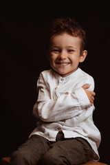 happy child boy preschooler smiling sitting on a chair