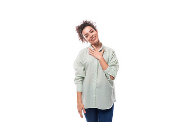 portrait of a charming sympathetic caucasian woman with black curly hair in a net shirt on a white background