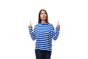 young slender brunette lady with straight hair dressed casually demonstrates space on the wall for advertising