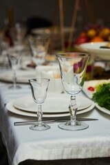 The setting of the festive table. Food and dishes. Festive glasses for drinks.