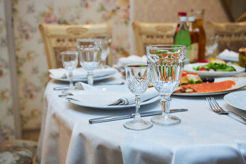 The setting of the festive table. Food and dishes. Festive glasses for drinks.