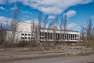 An abandoned structure with graffiti, under a blue sky with scattered clouds. The Energetik Palace...