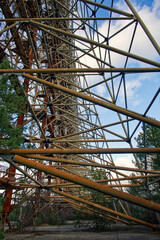 The photo captures an elaborate metal construction amidst sparse vegetation under a cloudy blue sky. Duga is a Soviet over-the-horizon radar station for an early detection system for ICBM launches.