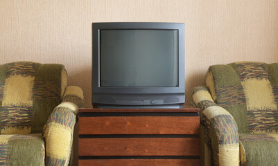 Vintage TV on wooden antique closet, old design in a home.Old black vintage TV. 