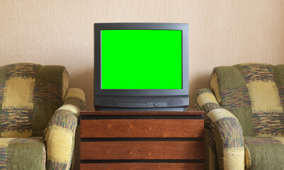 Vintage green screen tv on wooden antique cabinet, old house design.