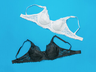 White and black classic women's bras on a blue background.