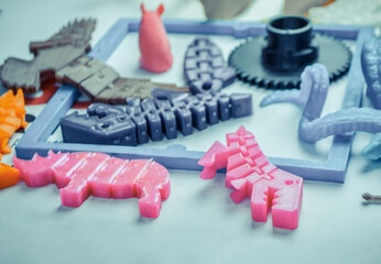 Models printed by 3d printer. Bright colorful objects printed on a 3d printer on a table close-up....