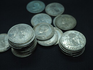Five peseta coins, silver coins of Alfonso XIII on a black background