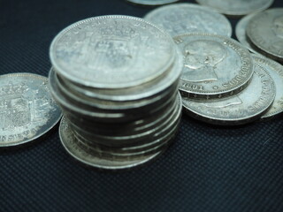 Five peseta coins, silver coins of Alfonso XIII on a black background