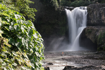 Long exposure shot of Tegenungan Waterfall on sunny day. Bali, Indonesia.