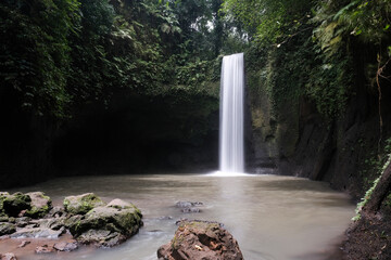 Long exposure shot of Tibumana waterfall on sunny day. Bali, Indonesia.