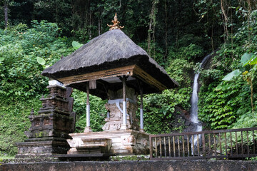 View of Pura Telaga Mas hindu temple and small waterfall on cloudy day. Lempuyang, Bali, Indonesia.