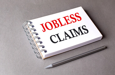 JOBLESS CLAIMS word on notebook on grey background