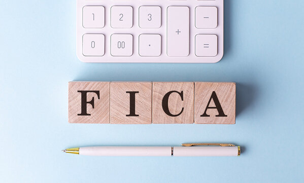 FICA on wooden cubes with pen and calculator, financial concept