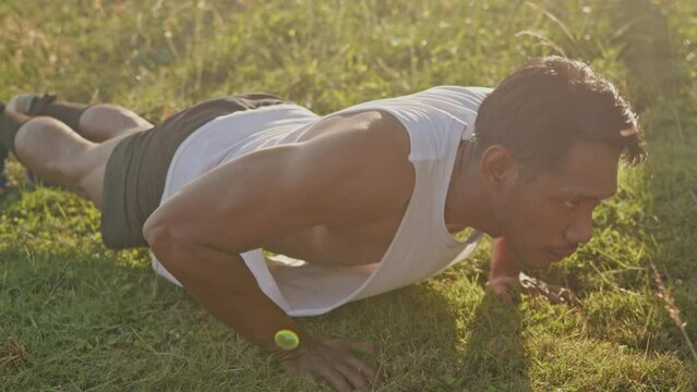 Sport man is stretching anf pushups after running or warm up before exercise in the park.