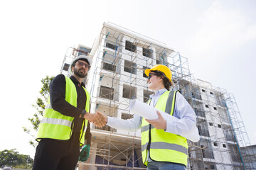 The architect team shake hands and joins in the construction work professionally. Construction business that works with teamwork building construction. Honest cooperation in investing