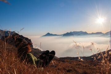 Genuine Mountain Young Woman Enjoying the Sunset View Over the European Alps, Lying in Winter...