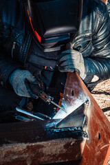 Welder works with metal, robot welder