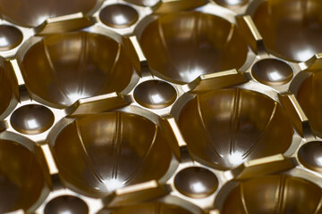 Closeup of repetitive brown metallic plastic container with multi dimples