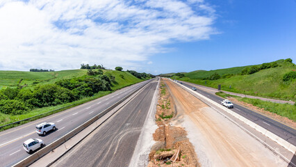 Driving Road Highway Overhead New Construction Expansion Of Vehicle Lanes in Countryside Landscape. - 697676603