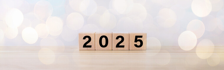 wooden cube year 2025 on wooden table.