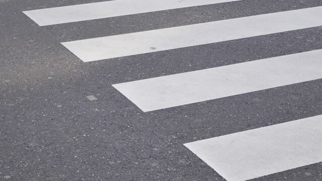 low angle view to the asphalt street at zebra crossing area at intersection while crowded of people pedestrian walking crossing ginza shopping street in Tokyo