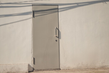 Metal close door with gray color and white wall. The photo is suitable to use for wallpaper background content media.