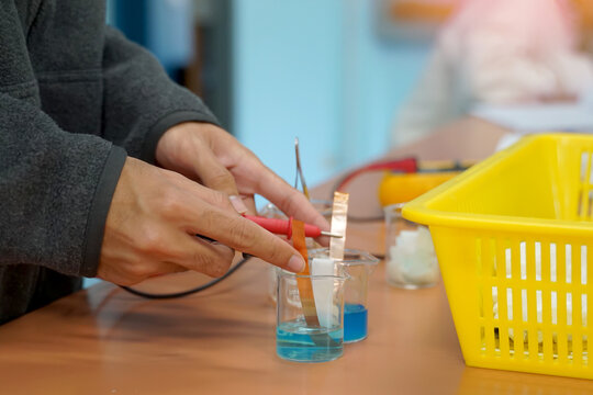 Students measure electric current by experimenting with creating a galvanic cell, which is an electrochemical cell that uses a chemical reaction to produce an electric current.