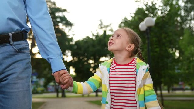 loving father walks with little child city park, family walk, happy child kid holds father hand, guardianship little kid, schoolboy with dad, kindergarten walk, nanny walks with child spring, male