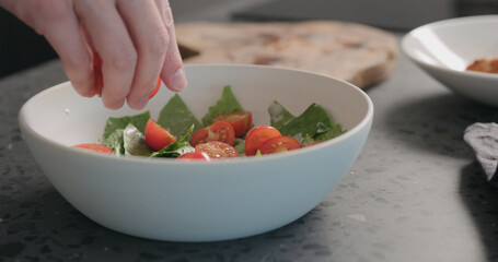 Man making salad with romaine and tomatoes