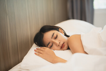 Asian woman sleeping with smart watch showing tracking heartbeat monitor in comfortable bed with...